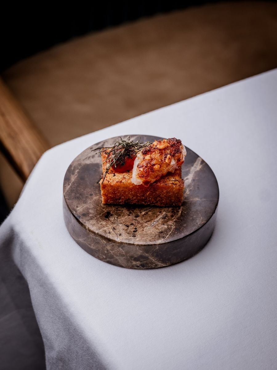 Gourmet appetizer placed on a circular stone base at The Capital Hotel, Apartments and Townhouse