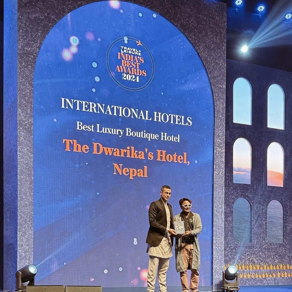 Two men holding an award by the International Hotels Award Banner at The Dwarika’s Hotels and Resorts