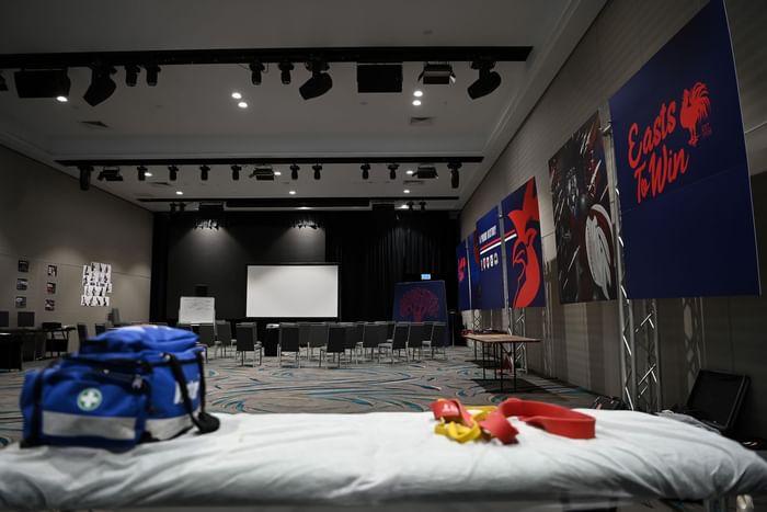 Classroom set-up facing a projector with first aid kit on a table in the foreground at Novotel Sunshine Coast Resort