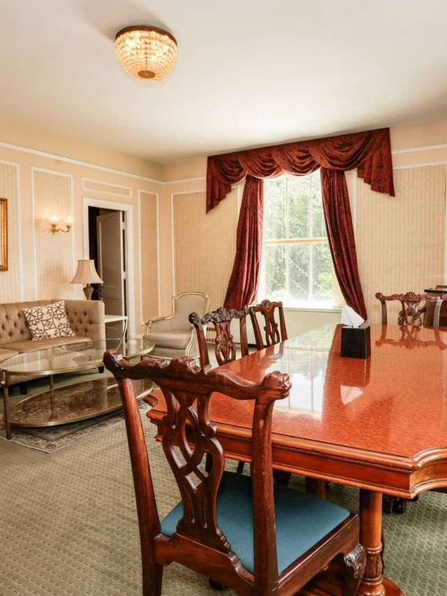 Elegant dining and living area in The Capone with red drapes and a large table at Arlington Resort Hotel & Spa