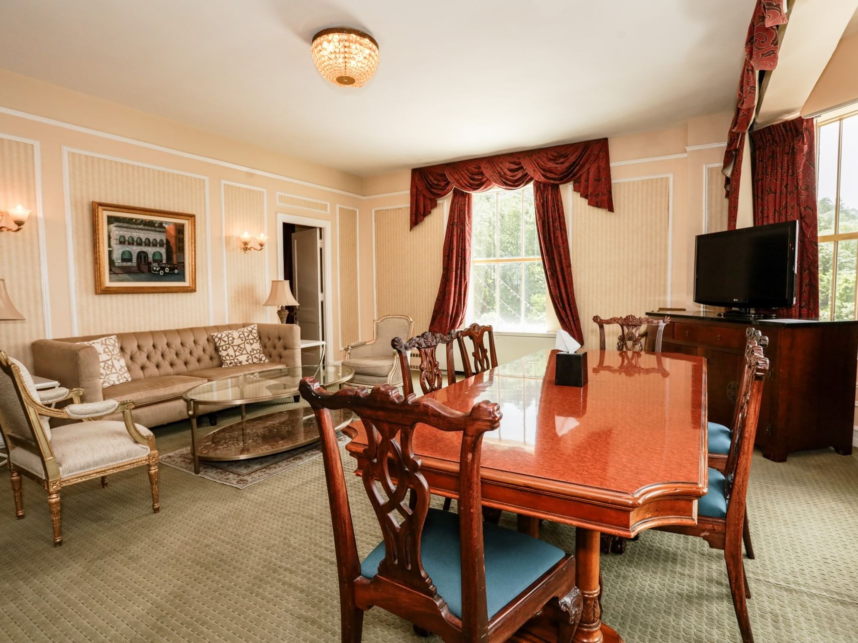 Elegant dining and living area in The Capone with red drapes and a large table at Arlington Resort Hotel & Spa