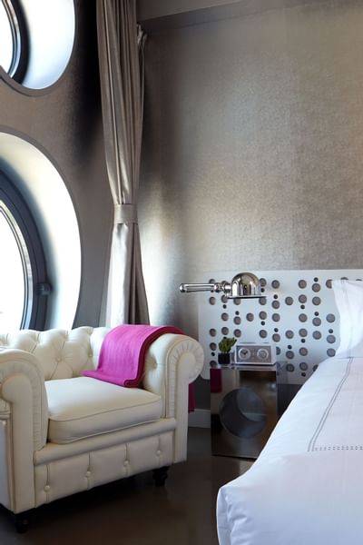 Overstuffed sofa next to the bed in Gold King at Dream Downtown