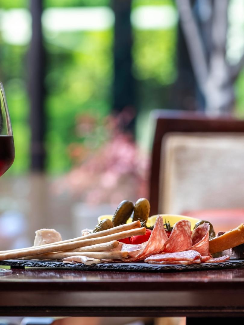 Two glasses of wine flank a charcuterie board with cured meats, breadsticks, & cheese served at Warwick Reine Astrid - Lyon