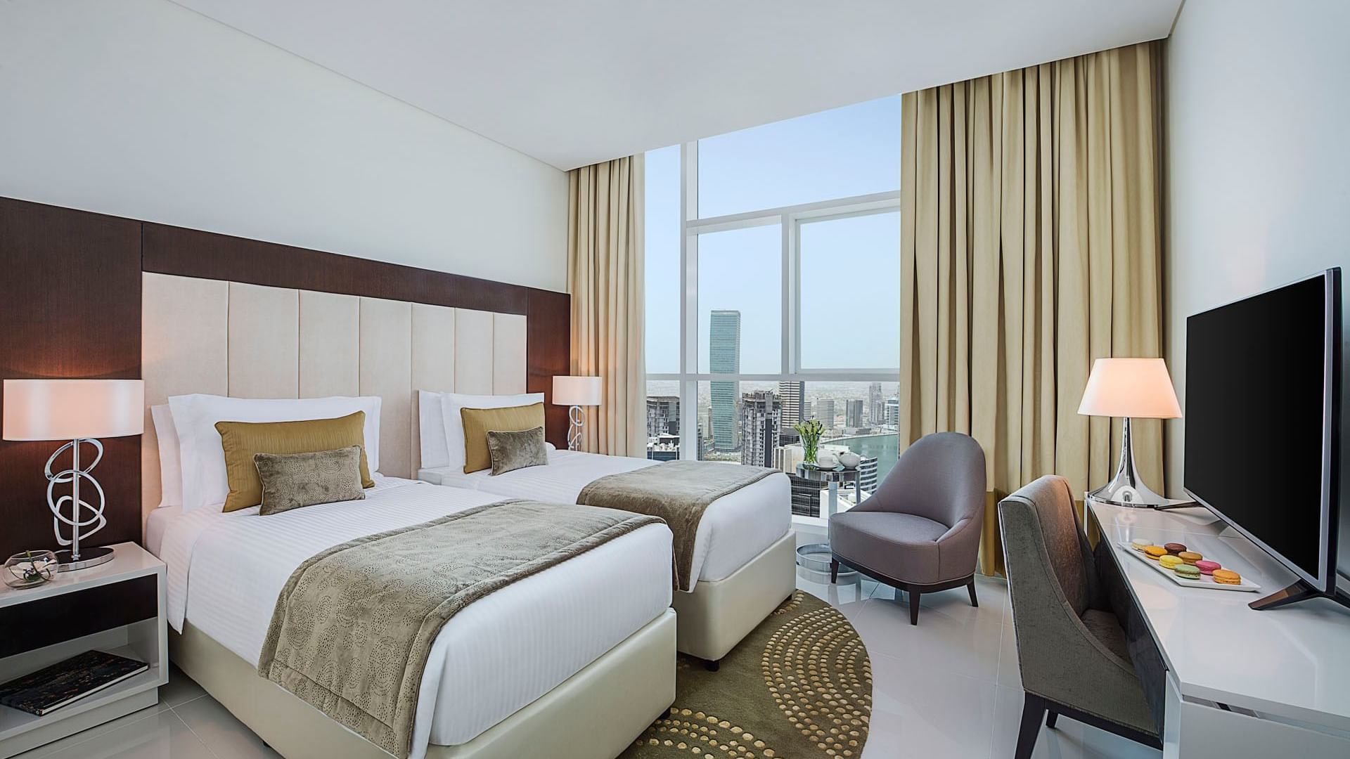 Twin beds by the window & a work desk in Three Bedroom Suite at DAMAC Maison Distinction