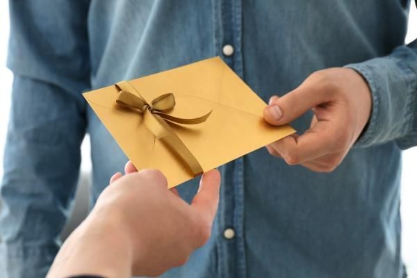 Groom to be handing out wedding invitation to his friend