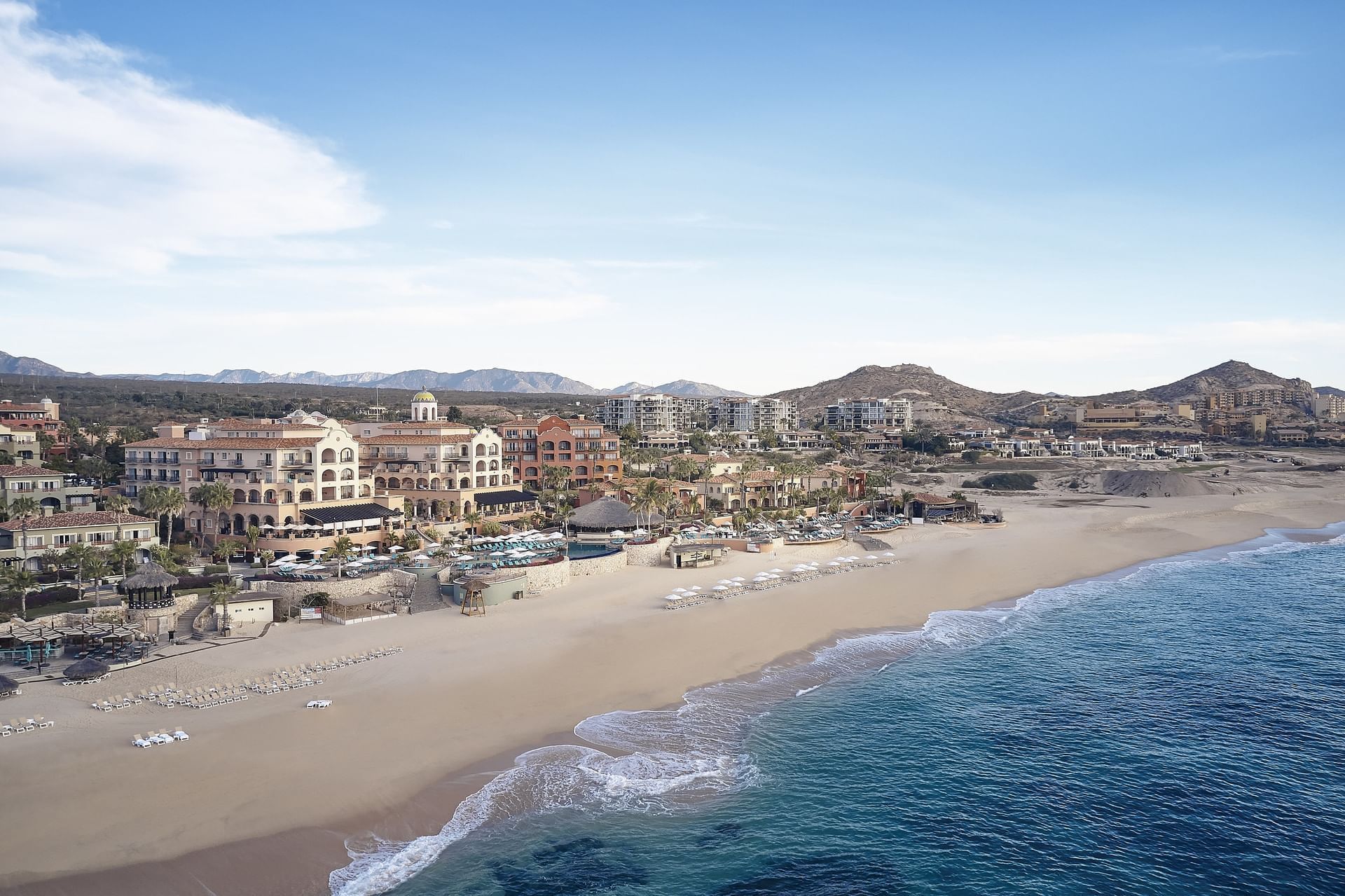 Vista panorámica del hotel frente a la playa a lo largo de una vasta arena y el Océano Pacífico.
