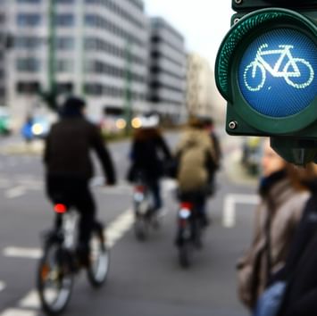 Passanten mit Fahrrädern an der Straßenkreuzung beim Sylter Hof Berlin