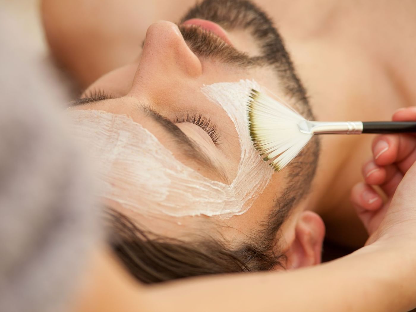 Man getting a facial treatment in a spa at La Colección Resorts