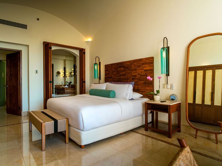King-sized bed with wooden accents and modern lighting in Master Suite at Marquis Los Cabos Resort