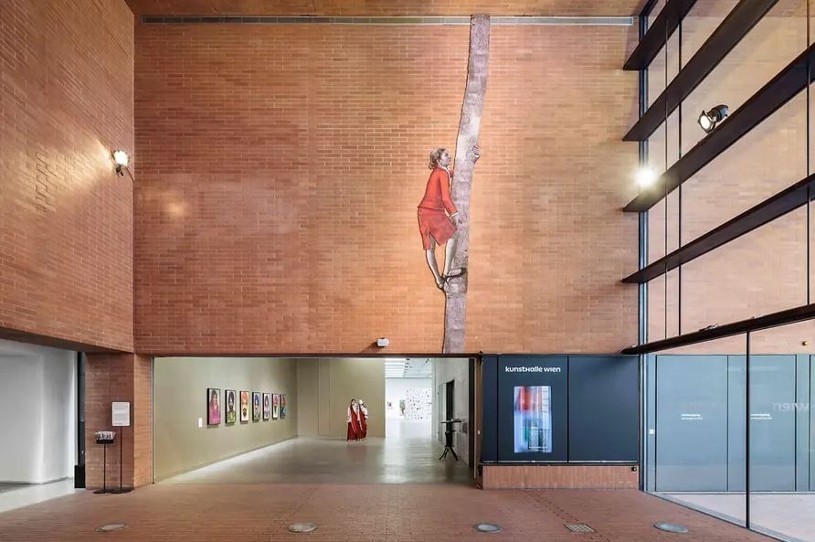 Kunsthalle Wien with modern entrance hall, tall brick walls, large art installation and a view into the exhibition galleries
