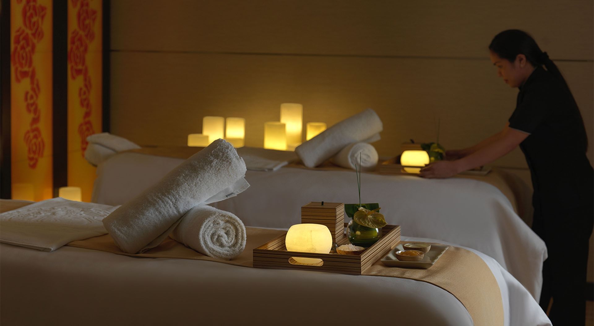 Spa Jardin with a serene spa setting with lit candles, towels, and a massage table at DAMAC Maison Cour Jardin