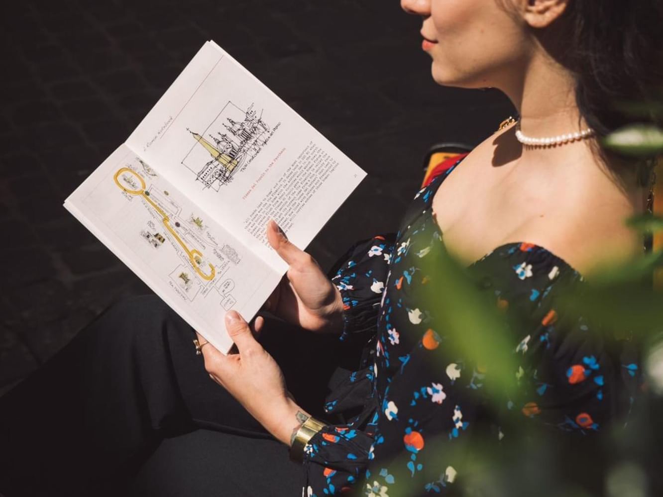 A woman sits on a bench and reading a book at Margutta 54