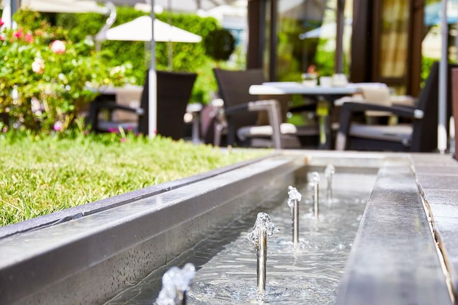 Outdoor setting featuring small fountains in a water feature in The Lounge Bar & Terrace at Warwick Reine Astrid - Lyon
