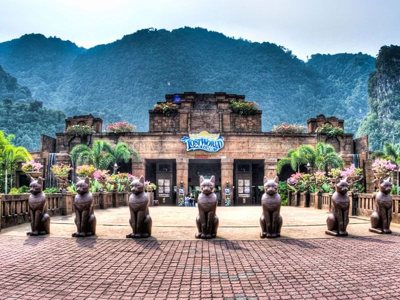 Wide shot of a Lost World of Tambun entrance with ornate statues near Cititel Express Ipoh