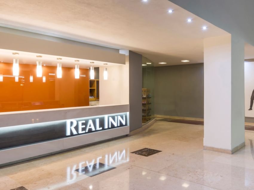 Modern Real Inn San Luis Potosi lobby with bright lighting, featuring a sleek reception desk with signage