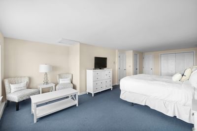 Bed and seating area with desk and a TV in Hightide Oceanview Three Bedroom Suite at Chatham Tides Resort