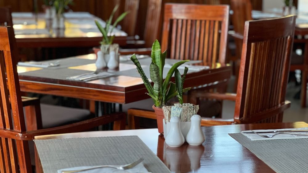 Wooden dining tables and chairs set at Bula Brasserie in Korolevu at Warwick Fiji Resort and Spa.
