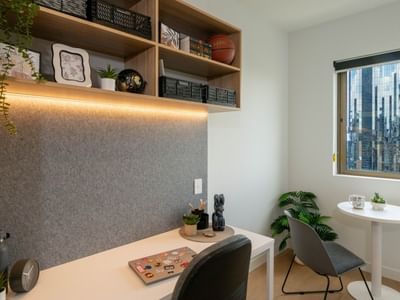 Modern office space with desk, chair, plants, and city view at UniLodge Brisbane City.