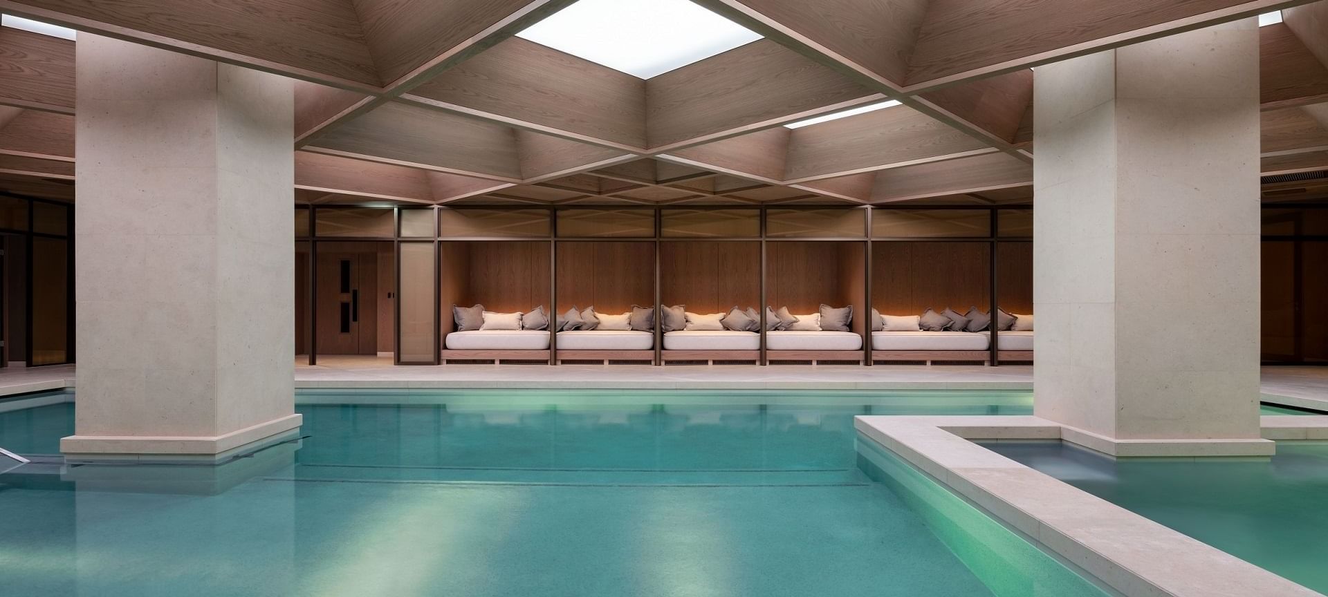 Indoor pool with sofa beds and square roof design with lightning at The Retreat Spa in The Londoner Hotel