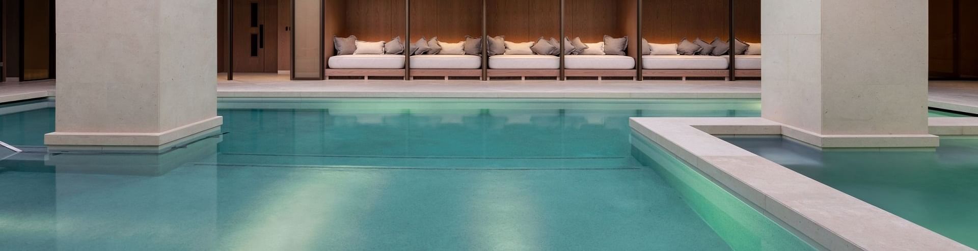 Hallenbad mit Schlafsofas und quadratischer Dachkonstruktion mit Beleuchtung im „The Retreat Spa“ des „The Londoner Hotel“