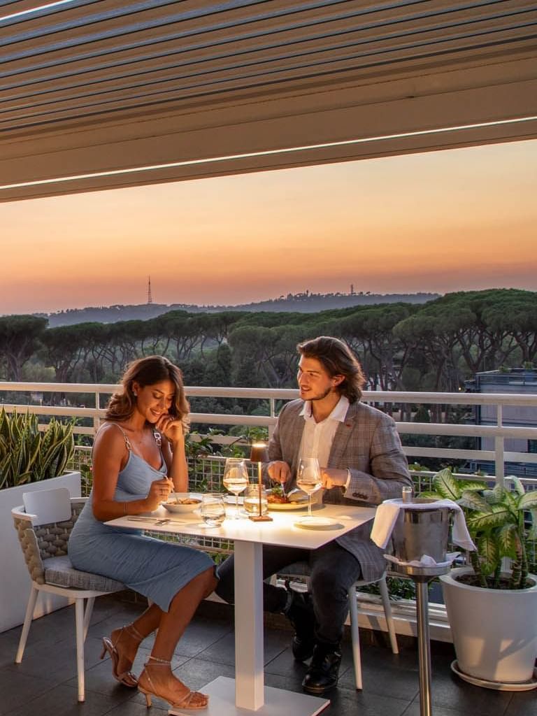 Terrazza Borghese with set tables and diners enjoying a picturesque view of the city skyline at The Tribune Hotel