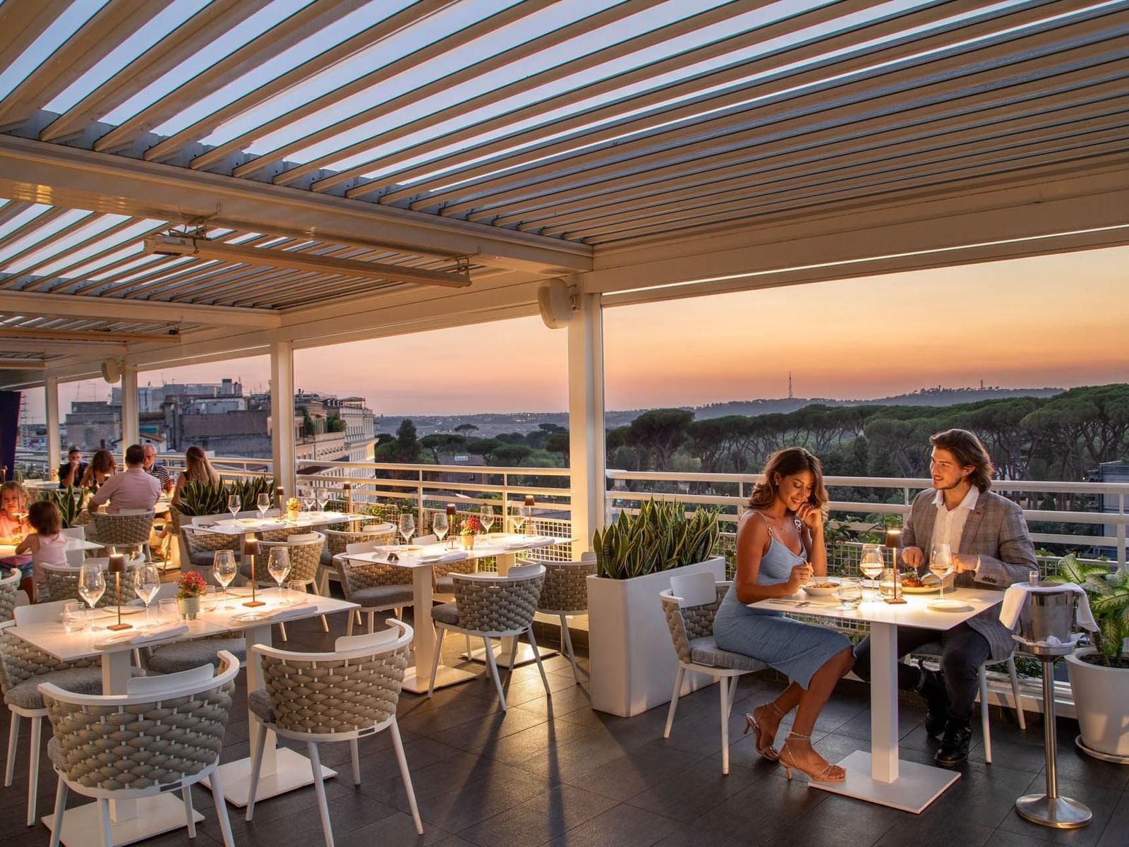 Terrazza Borghese with set tables and diners enjoying a picturesque view of the city skyline at The Tribune Hotel