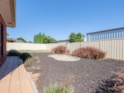 Backyard with a brick house and fenced yard at La Trobe University Regional Housing – Mildura.