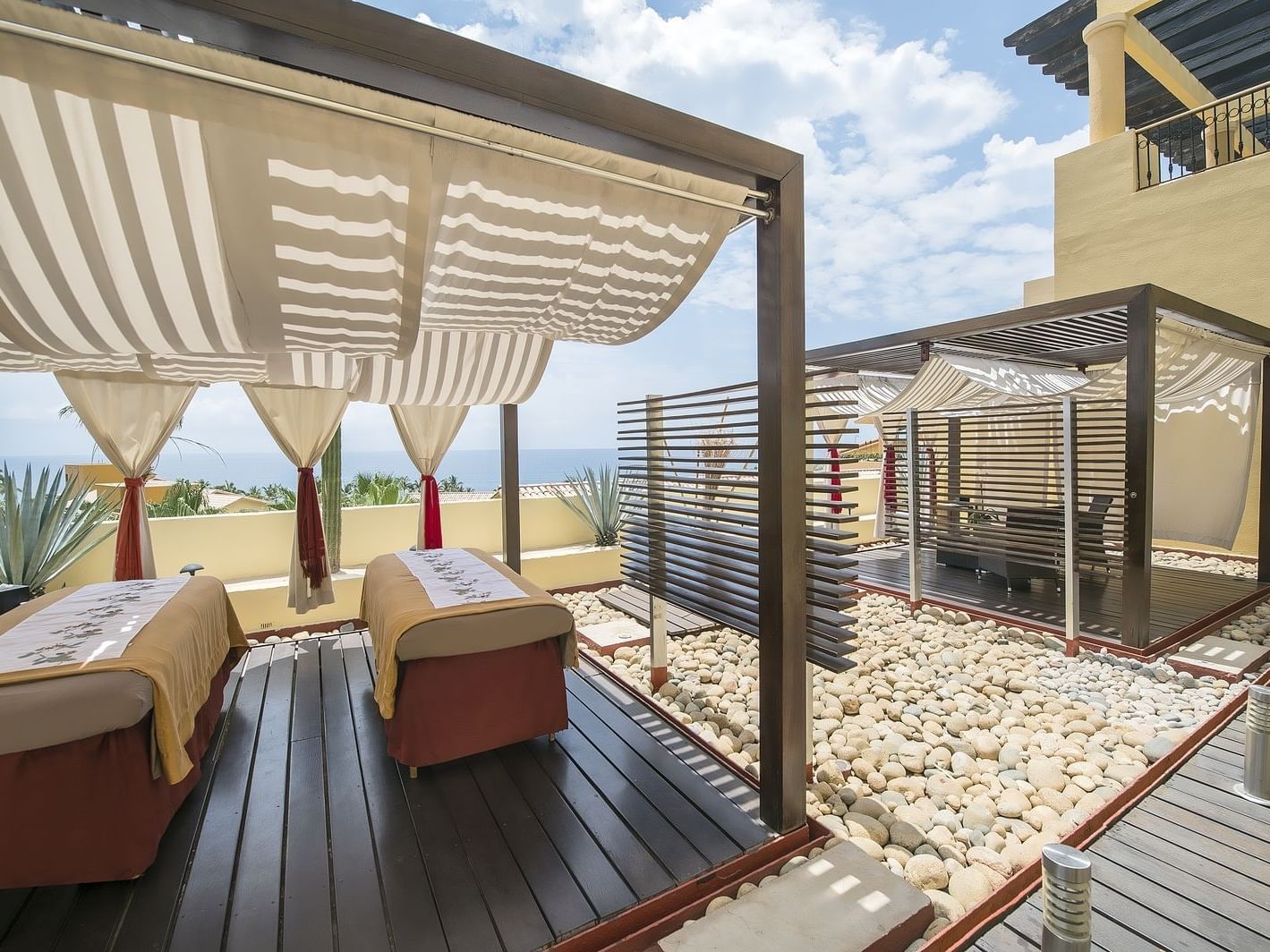 Outdoor spa beds with curtains at La Colección Resorts
