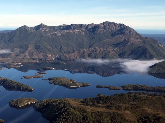 Aerial view of mountains around with a lake near Strahan Village