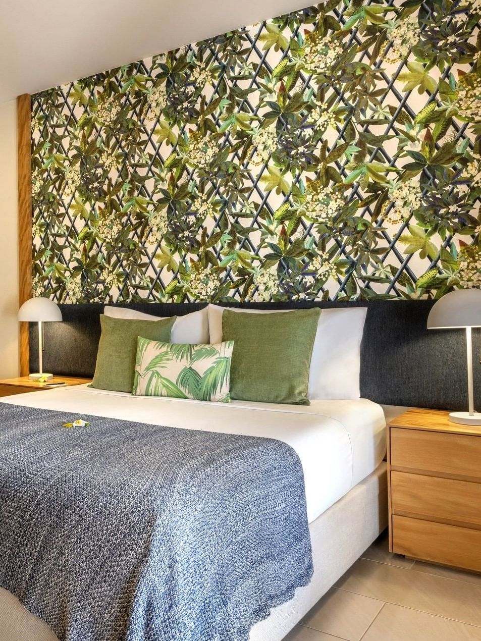 Decorative floral wall with large bed beside small sofa in Lagoon Superior Room at warwick le lagon-vanuatu