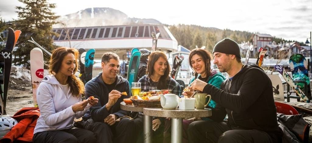 Friends dining outdoors near Whistler ski lifts