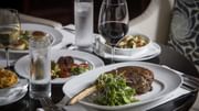 Dining setting with steak, salad and wine in Diplomat Prime at Diplomat Beach Resort