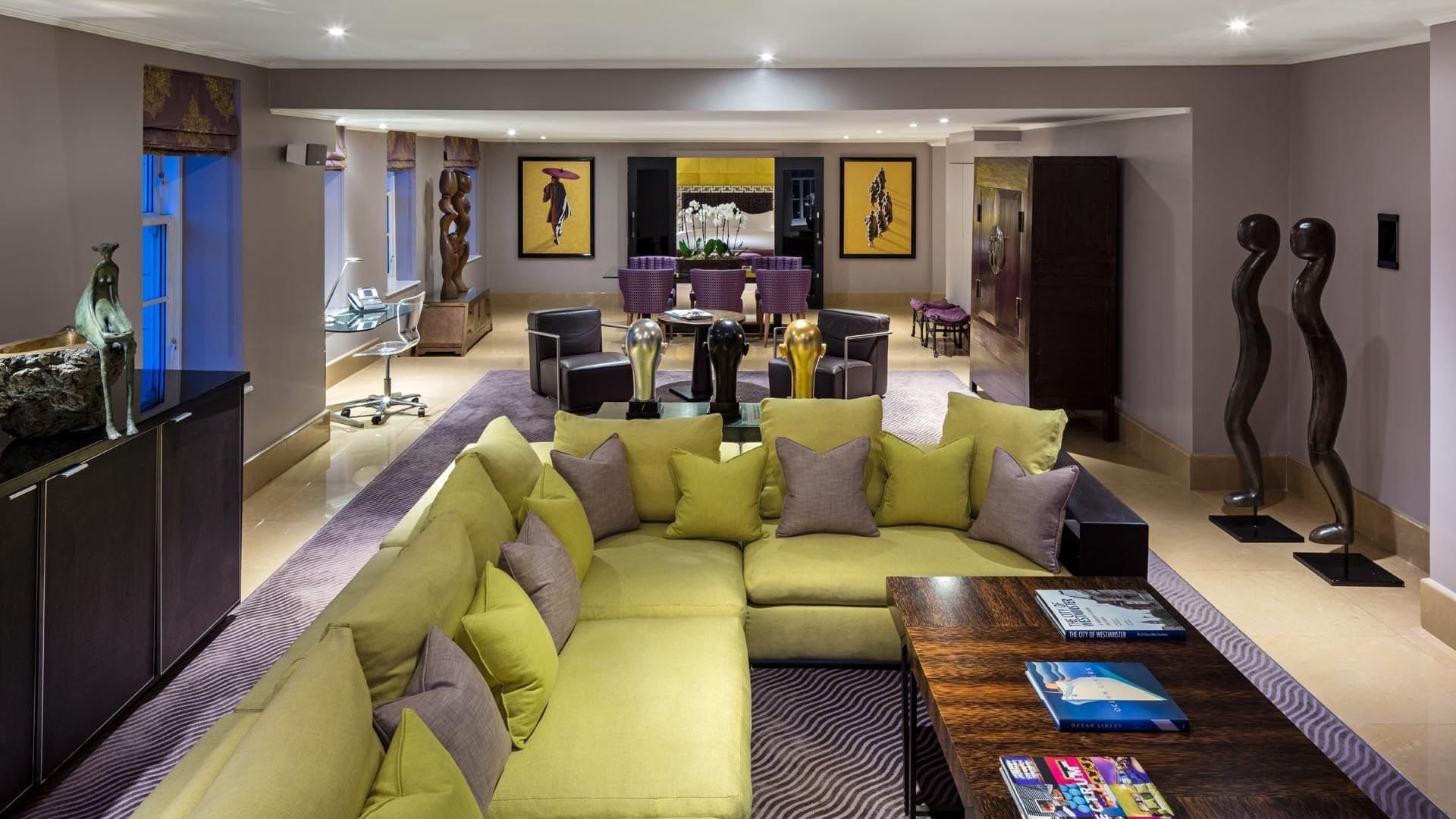 Modern living room in The Amarillo Suite at The May Fair Hotel London, featuring a sectional sofa and sculptures