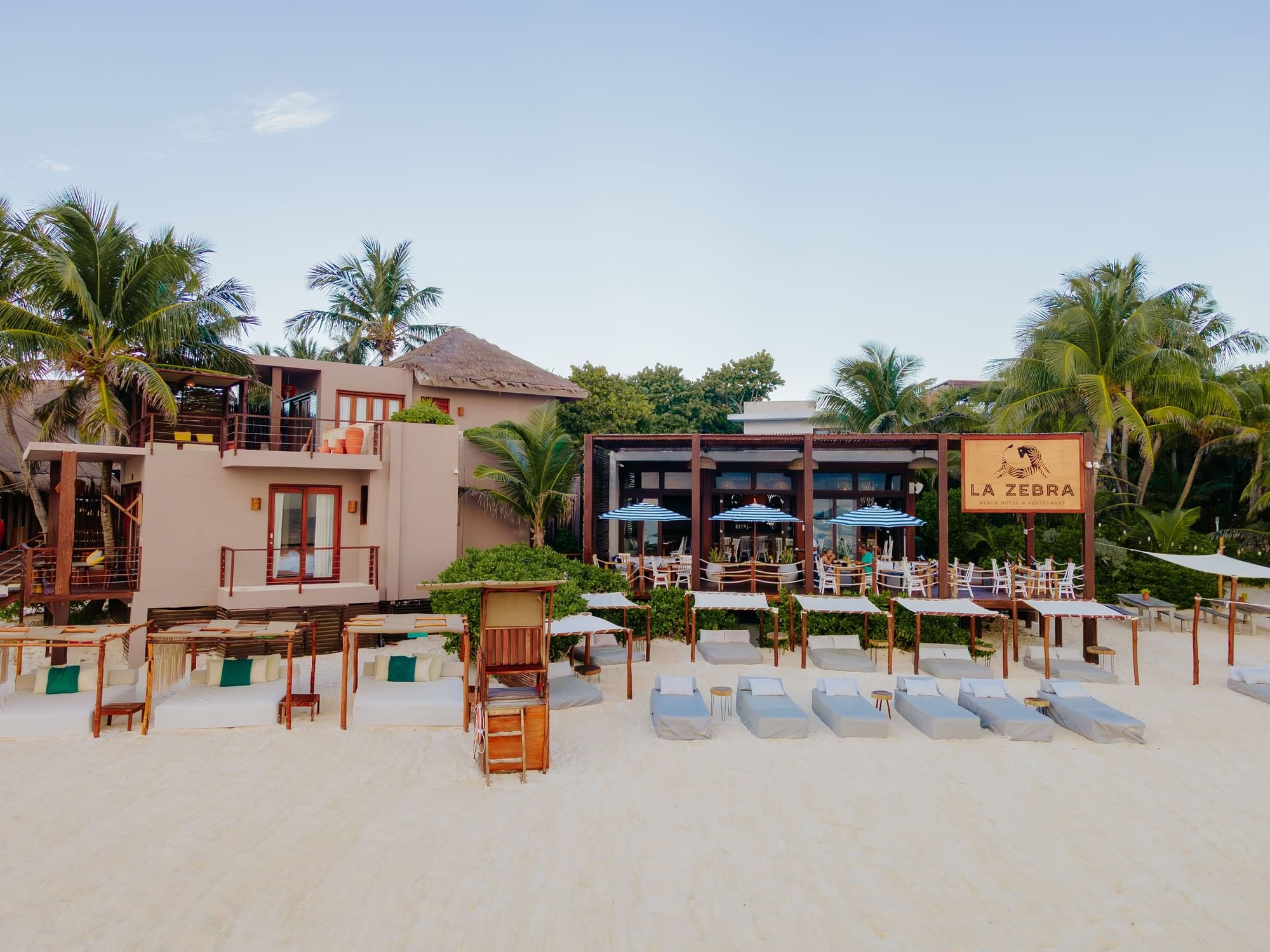 La Zebra’s beachfront rooms, restaurant and shaded beach beds beneath the palms in Tulum.