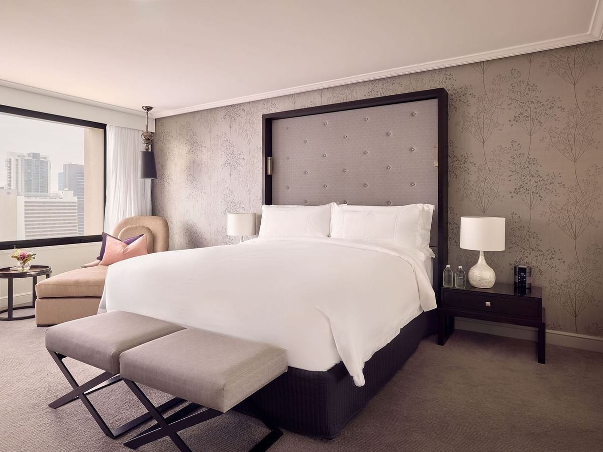 Bedroom with king-sized bed, and floral wallpaper in Signature Suite Room at Sofitel Brisbane Central