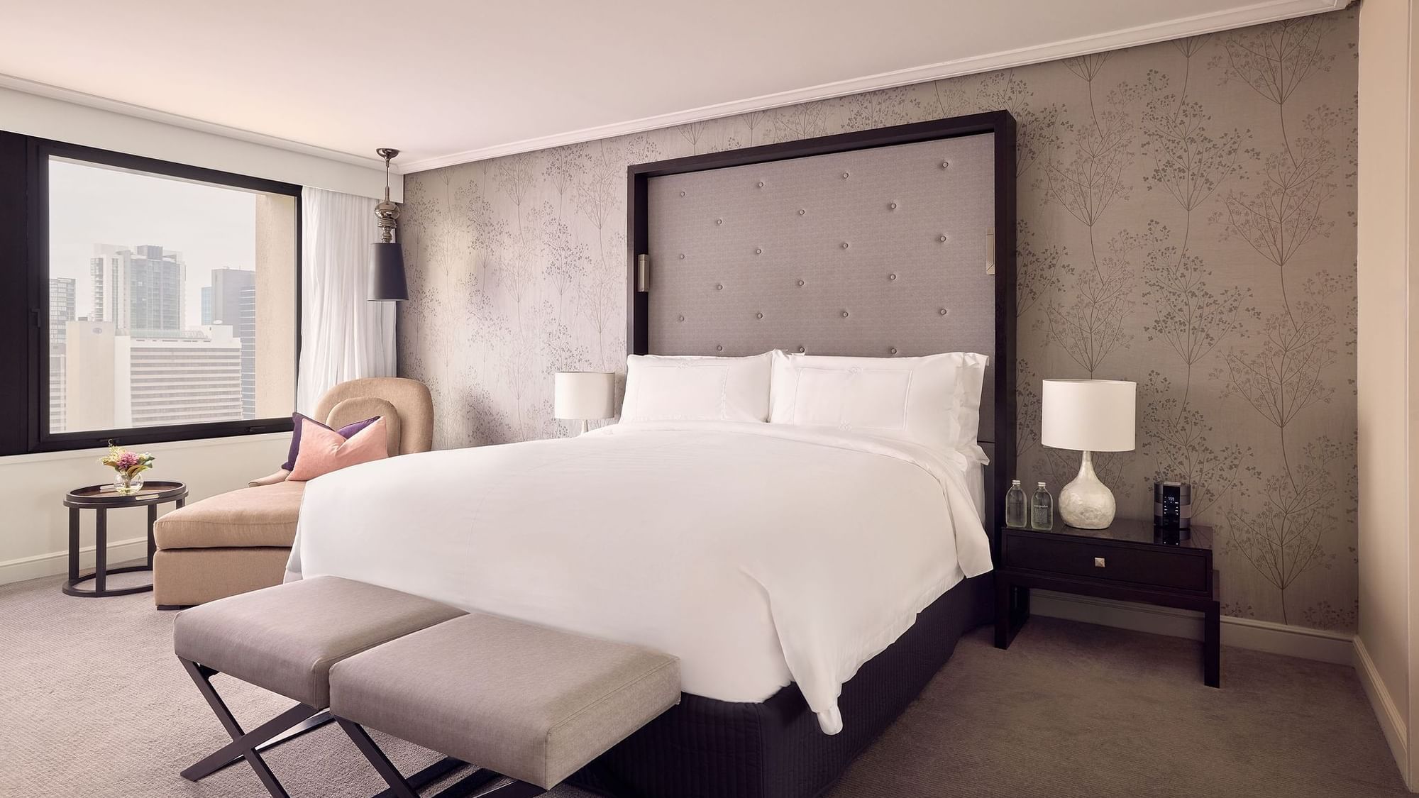 Ottoman and lounge chair by the bed in Signature Suite at Sofitel Brisbane Central