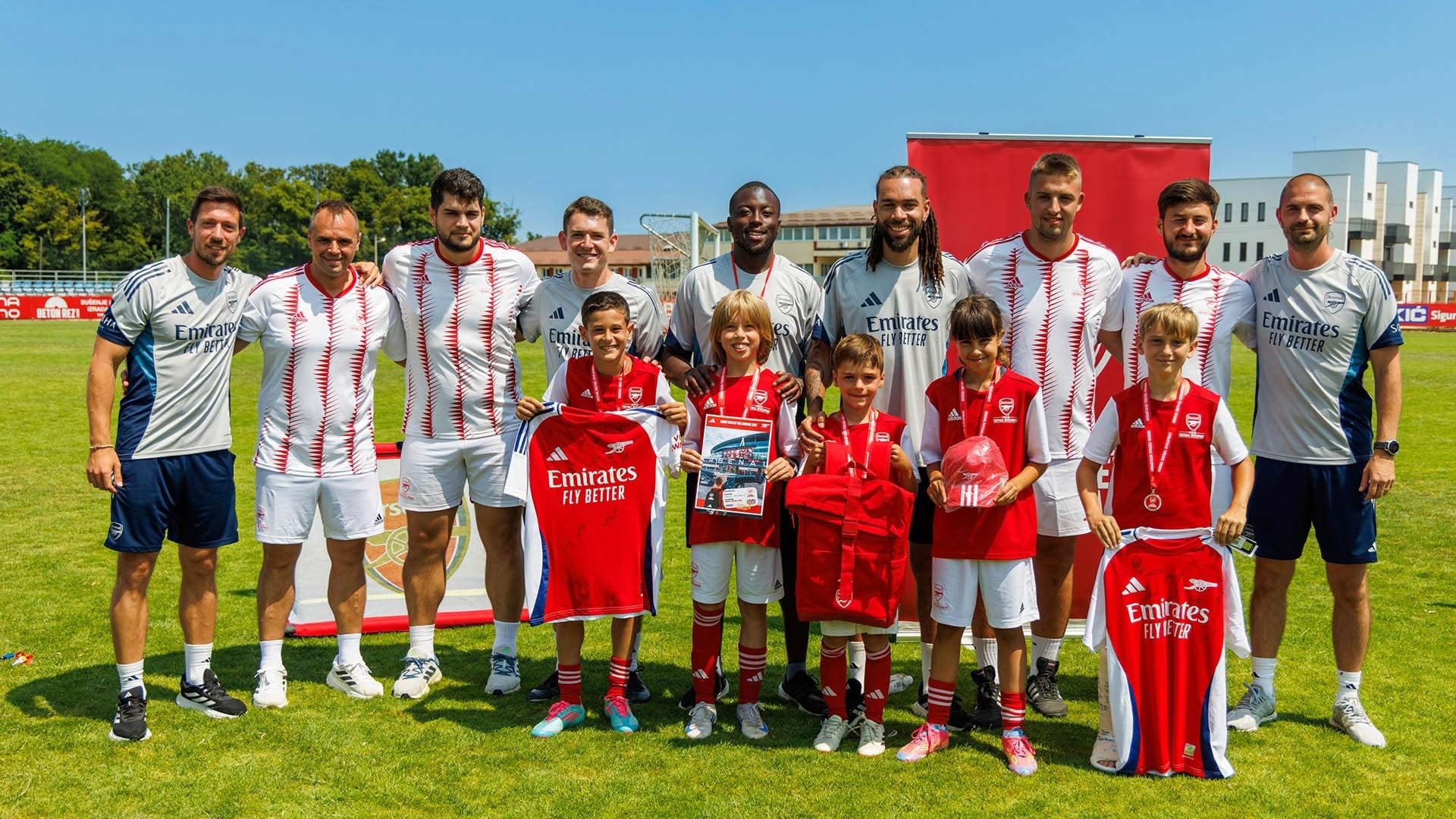 Nogometni tim i mladi igrači s dresovima na travnjaku s panoama Falkensteiner Resort Punta Skala