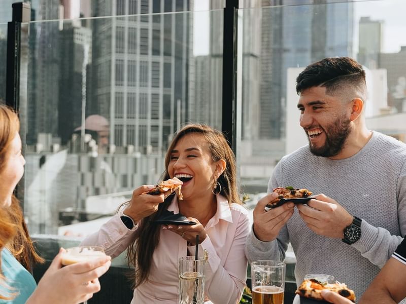 People dining in Blossoms Rooftop Bar at Pullman Melbourne City