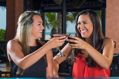 two women cheers cocktails