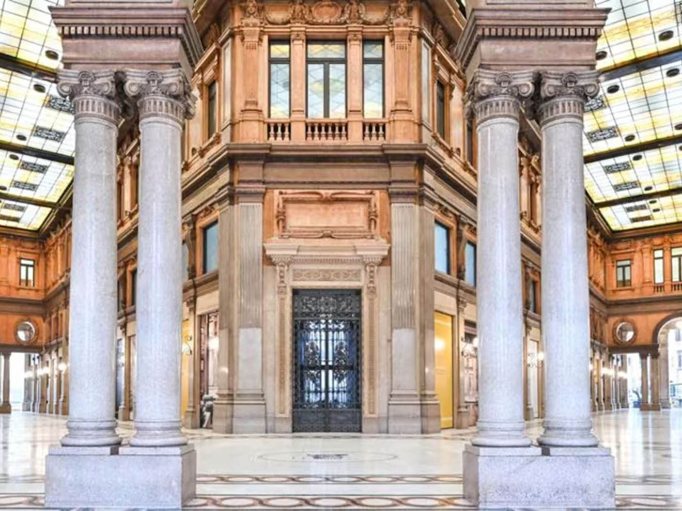 Elegant interior of Galleria Alberto Sordi with tall columns, intricate details, and skylights near The Guardian Hotel