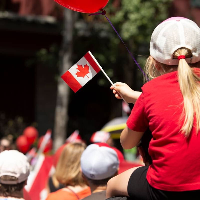 Little girl holding a Canadian flag on the Canada Day near Blackcomb Springs Suites
