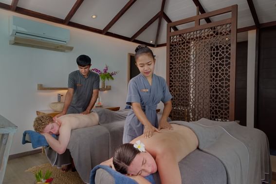 A Man and lady receiving relaxing massages in a spa at Grand Park Kodhipparu, Maldives