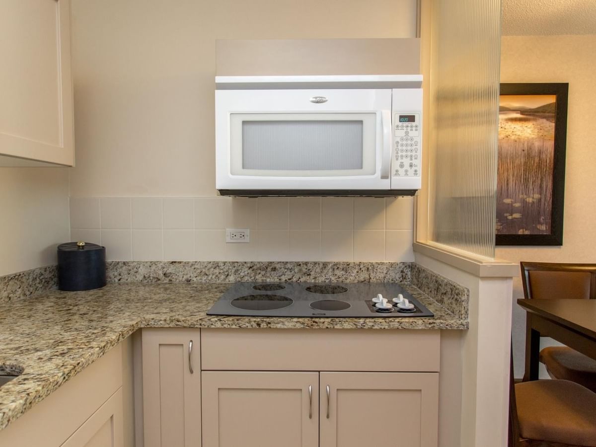 Hotel suite kitchenette with stovetop and microwave.