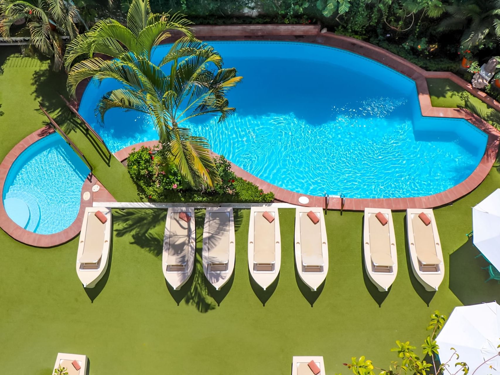 Aerial view of sunbeds by the outdoor pool at Los Arcos Suites