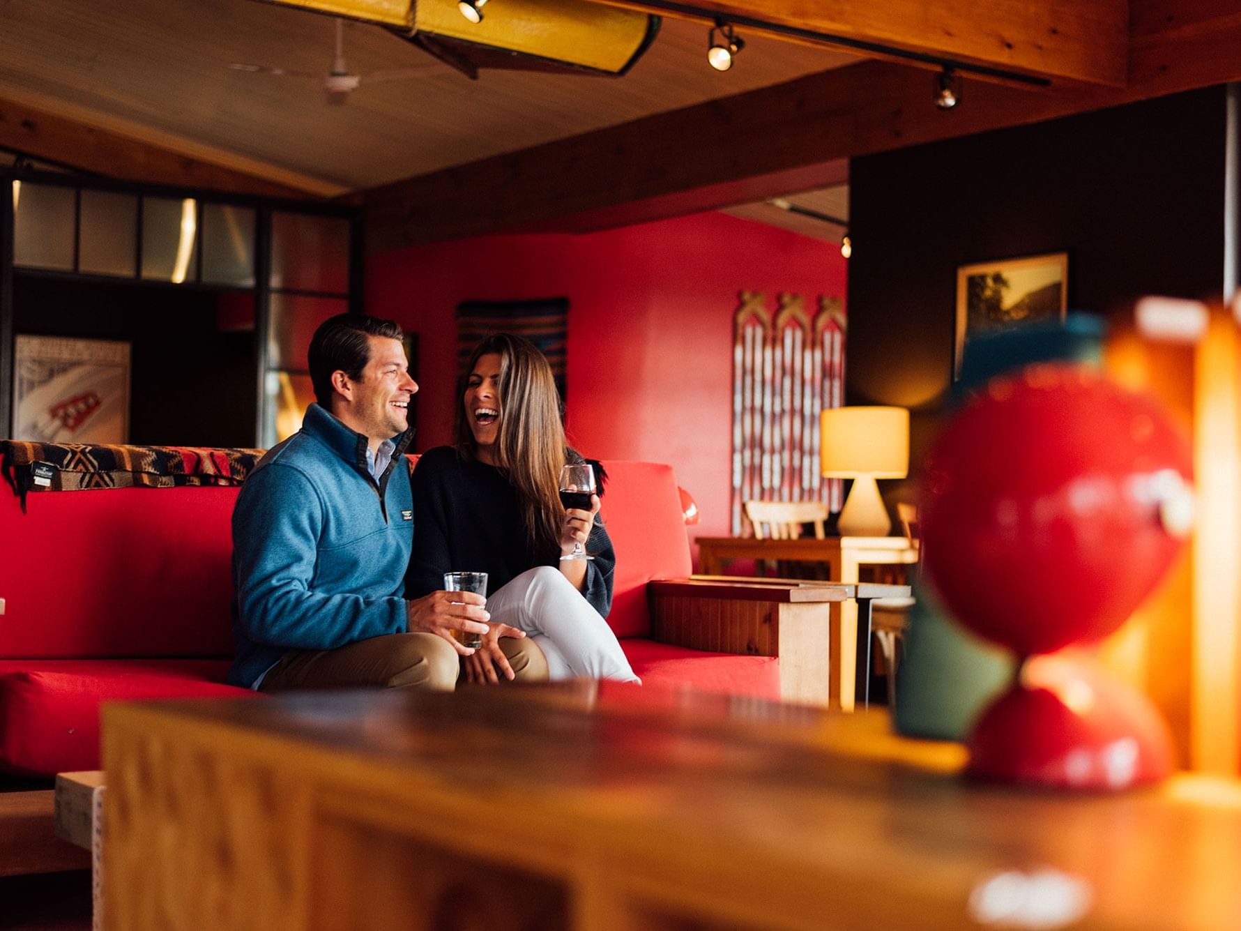 Couple laughing over a glass of wine in Lake House great room.