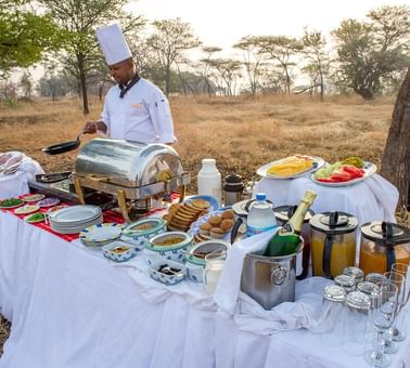 A chef preparing breakfast Outdoors at Kirawira Serena Camp