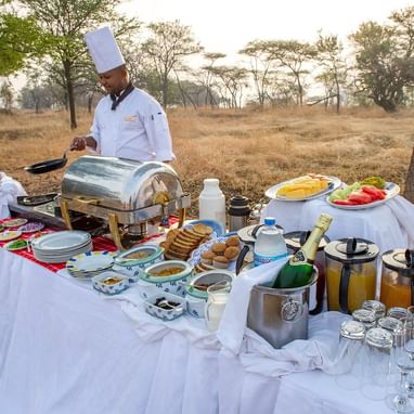 A chef preparing breakfast Outdoors at Kirawira Serena Camp