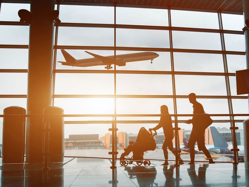 A family looking at an airpalne taking off at the aiport