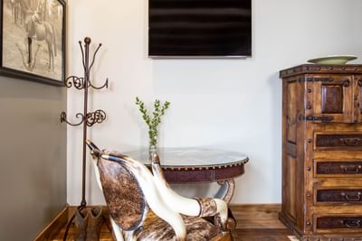 Round dining table, wing chair, TV & cupboard in King Premiere Wild West at Retro Suites Hotel