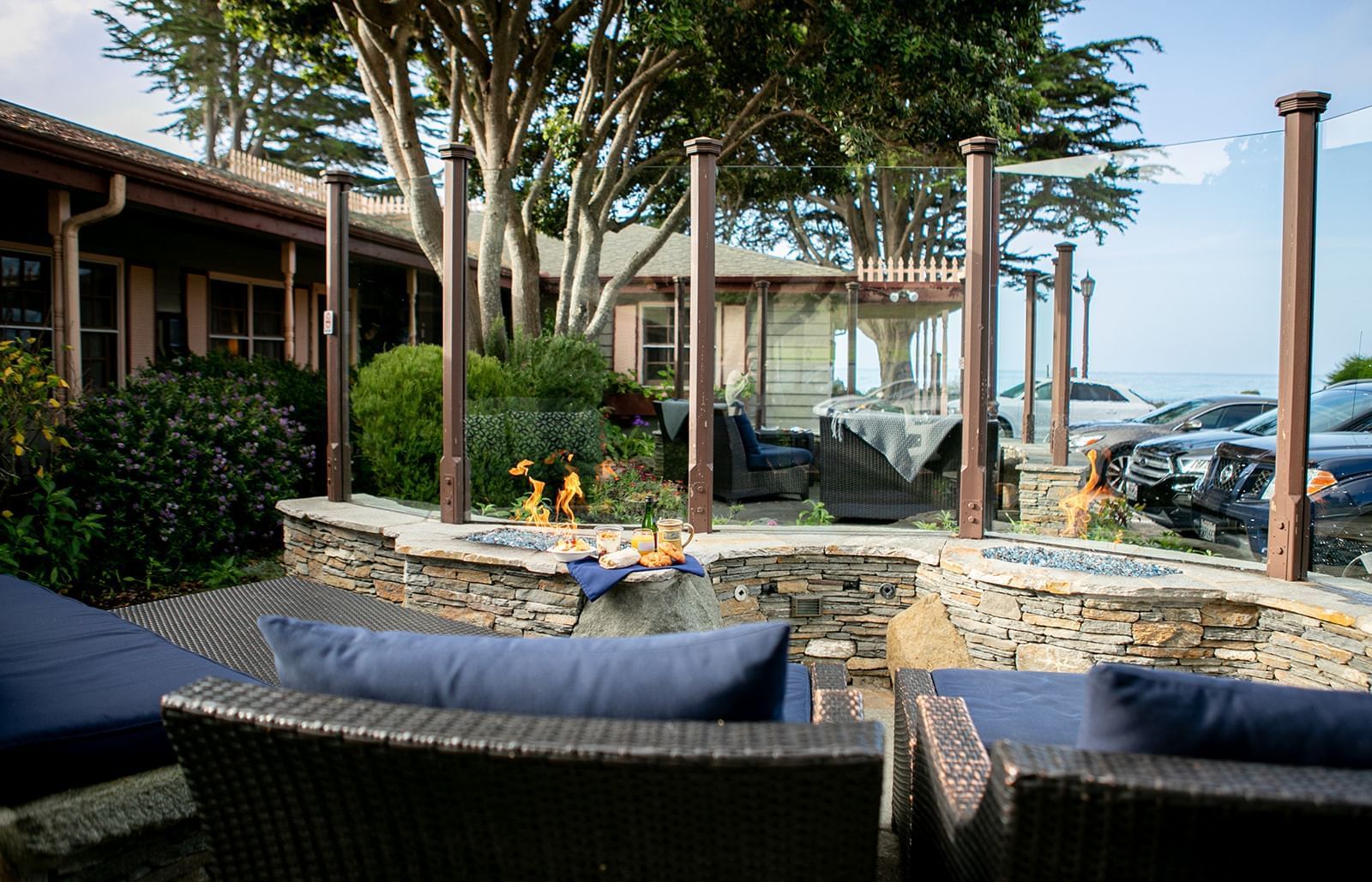 A cozy outdoor seating area with a fire pit and stone wall.